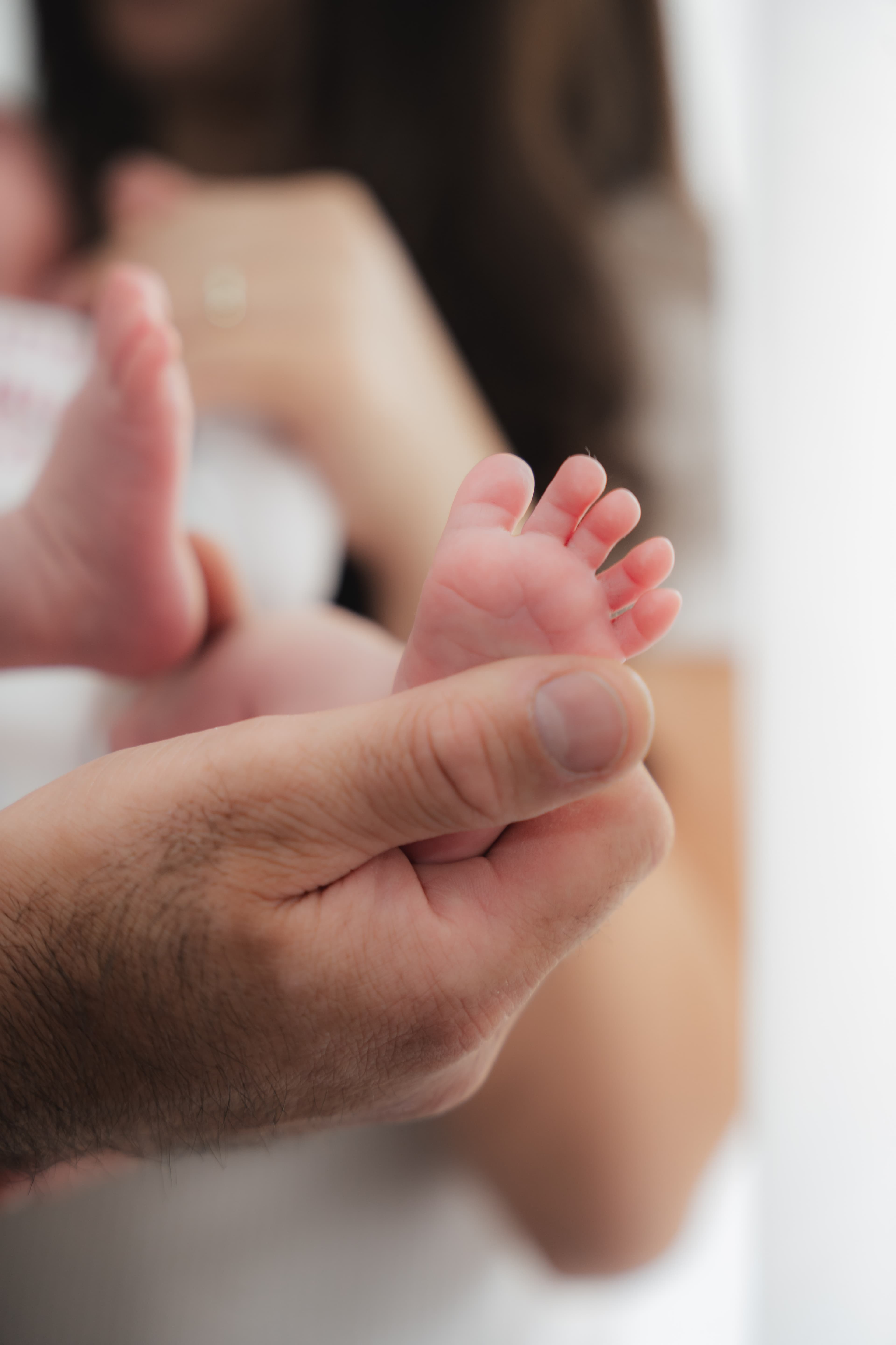 Babyfüße in Papas Hand