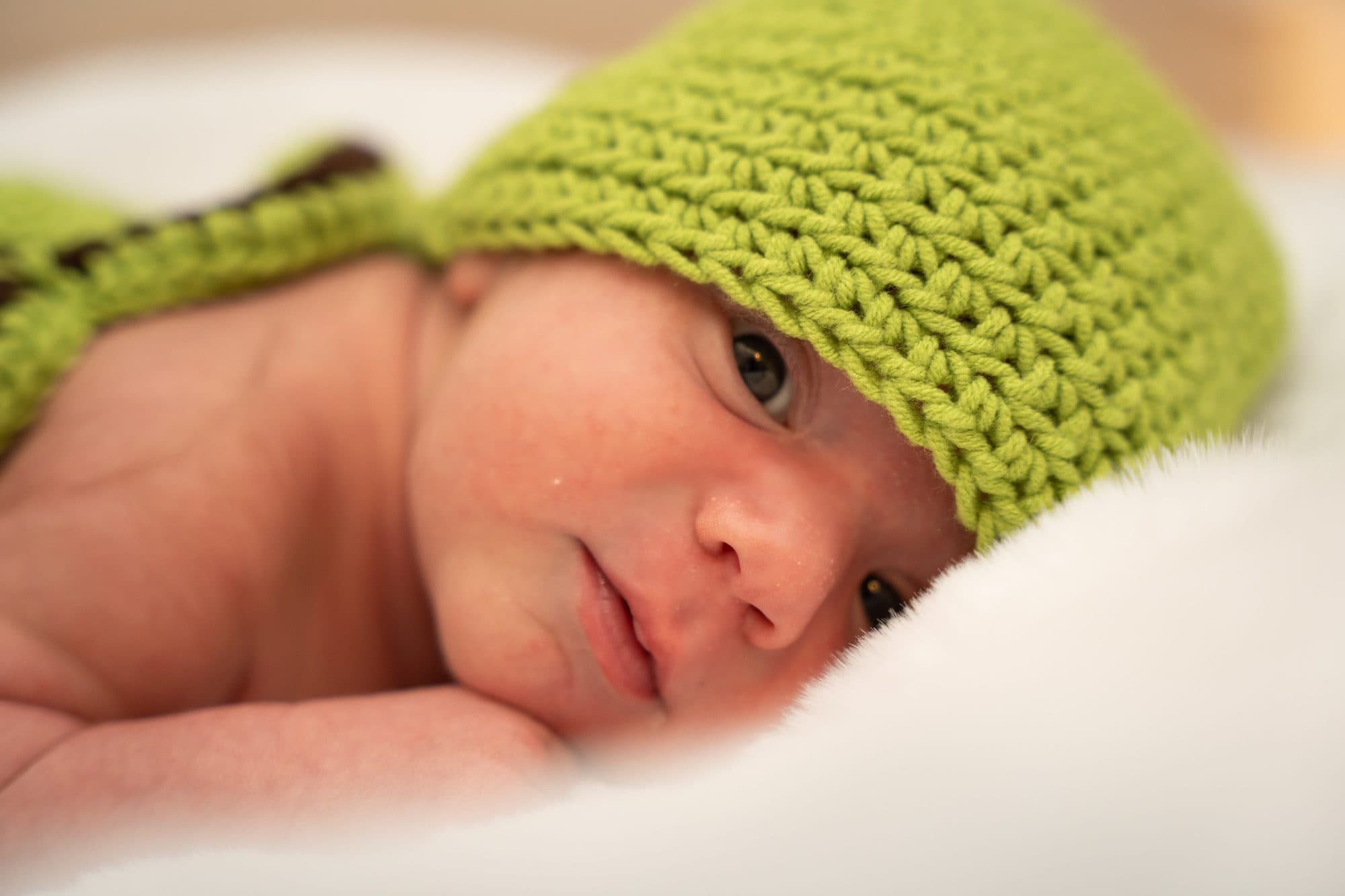 Baby mit grüner Strickmütze