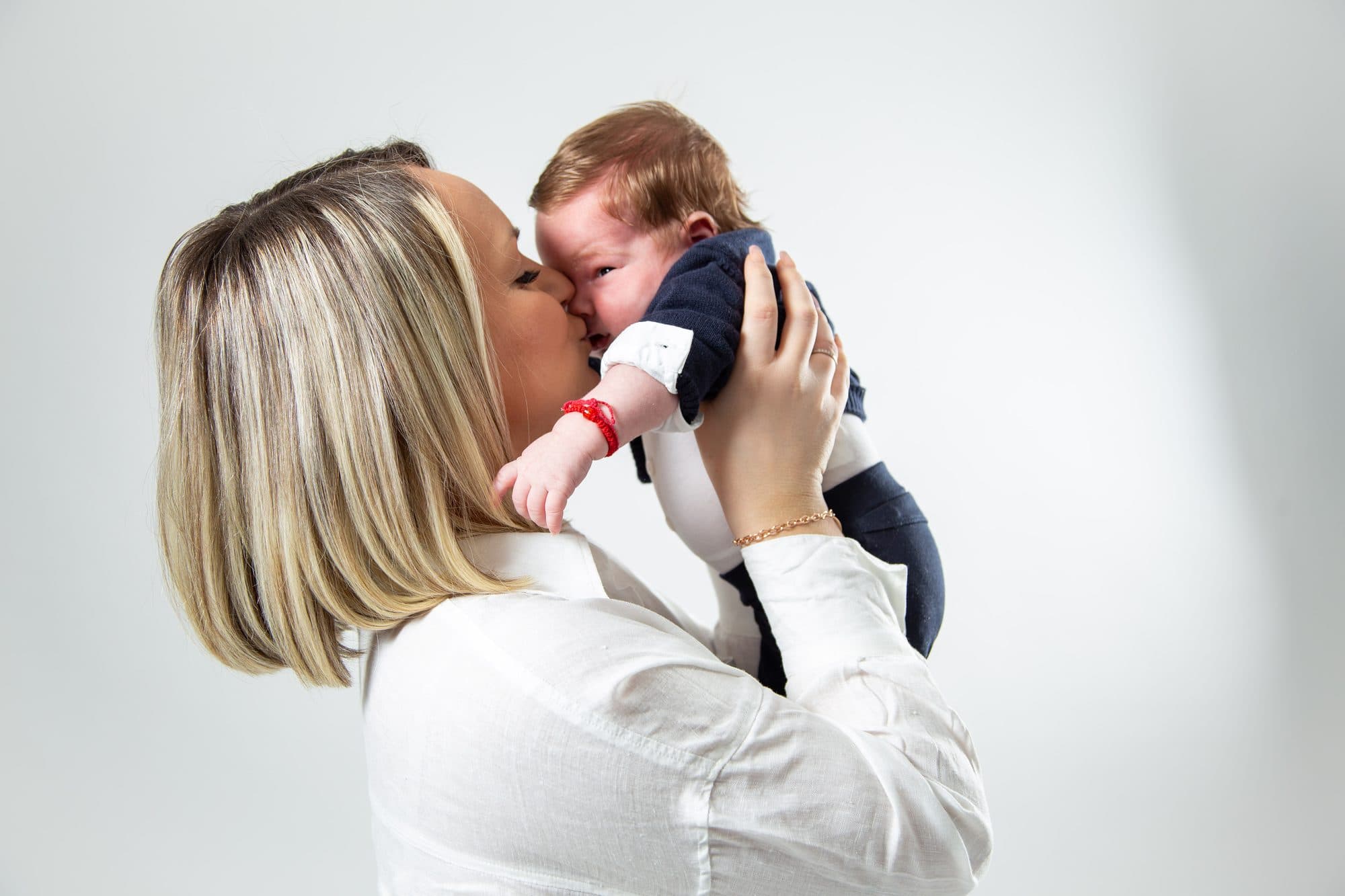 Mutter küsst neugeborenes Baby